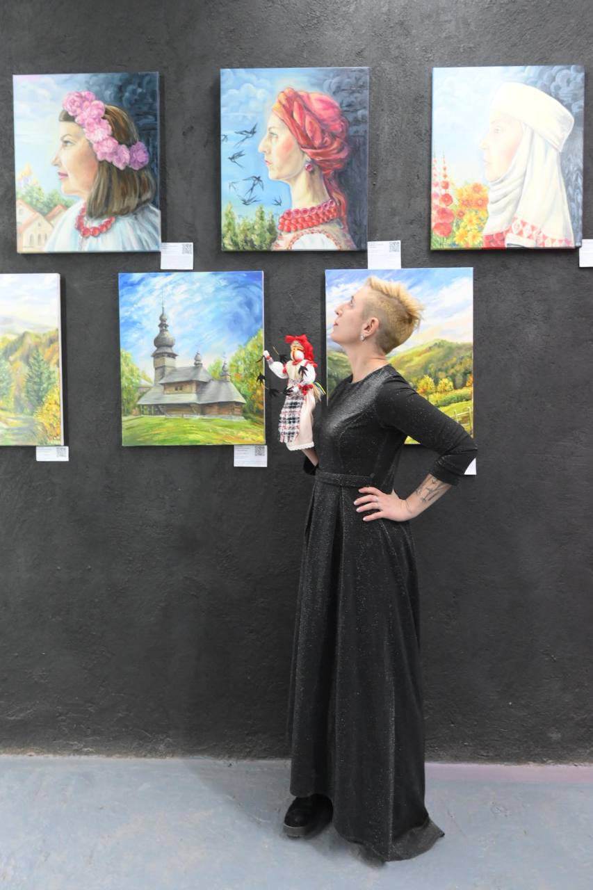 Кураторка проєкту художниця Олена Каїнська біля свого портрета, який написала Світлана Бойкова-Калюжна